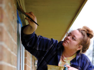 Lara Armstrong painting window trim