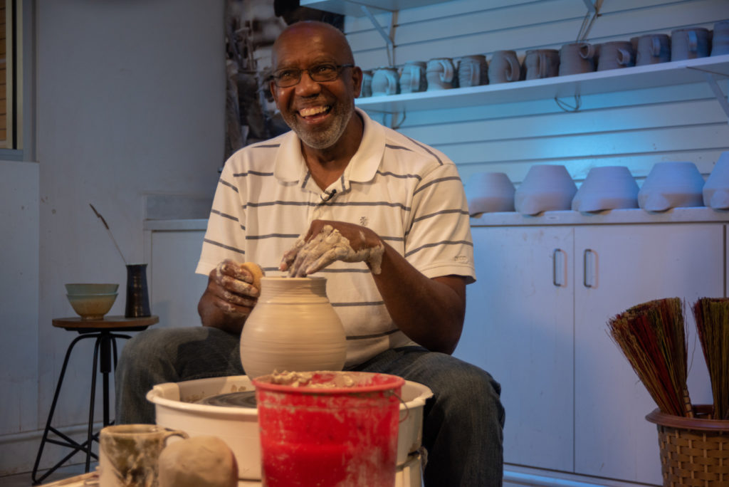 Larry Allen throwing a vase on a pottery wheel