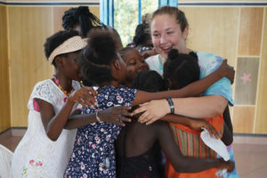 Rachel Starnes hugging a group of children