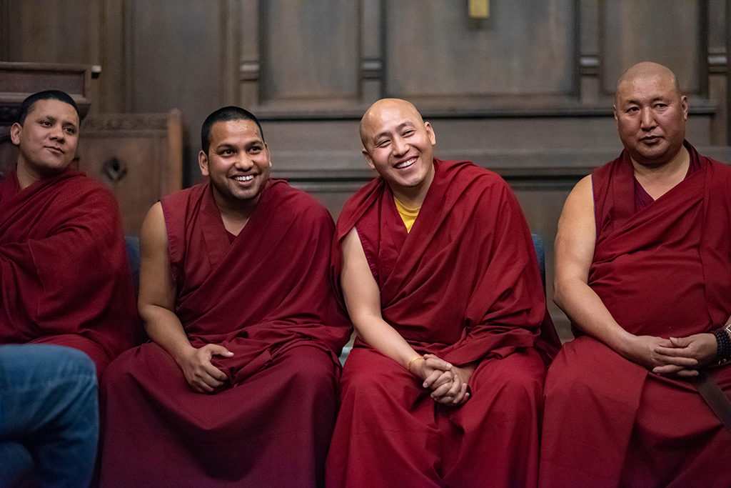 a group of Tibetan Buddhist Monks smile for a photo