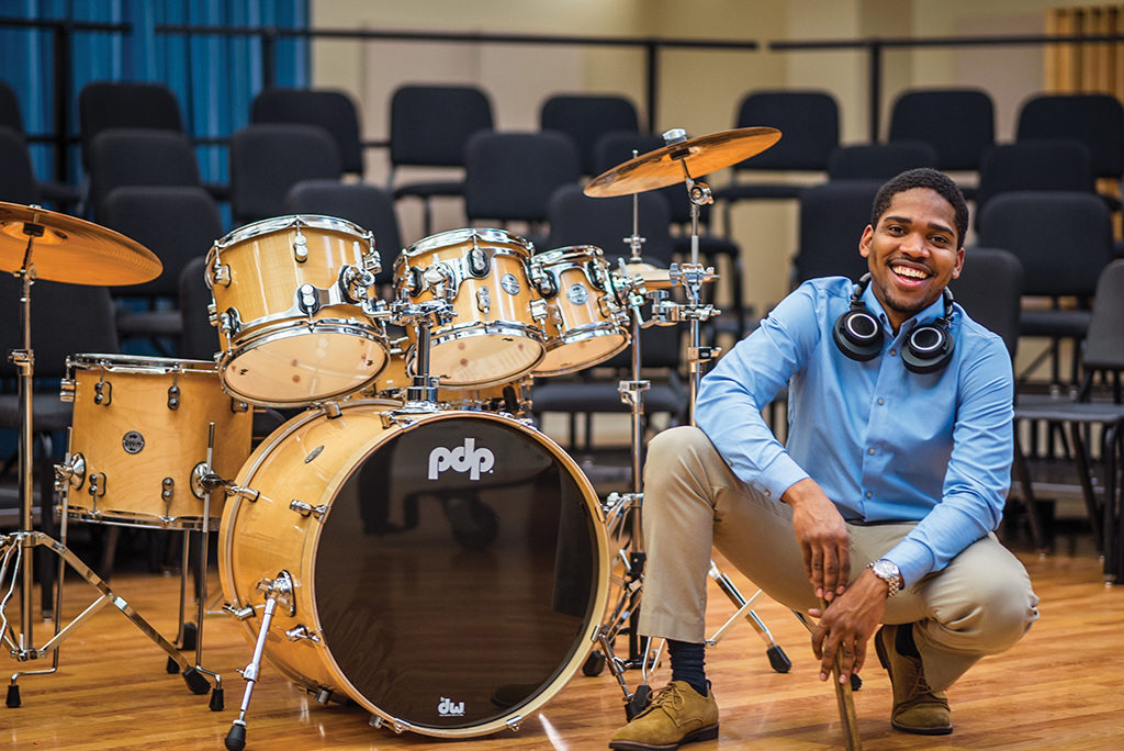 Wilkensley Thervil sitting next to a set of drums
