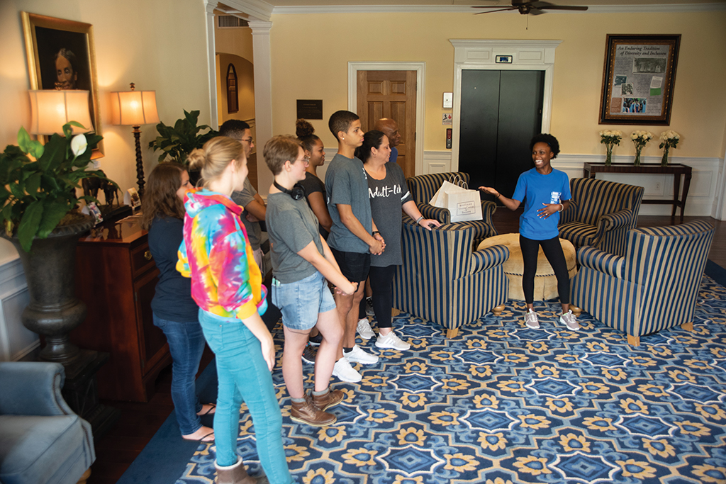 Student tour guide leading a group through Boone Tavern Hotel and Restaurant.