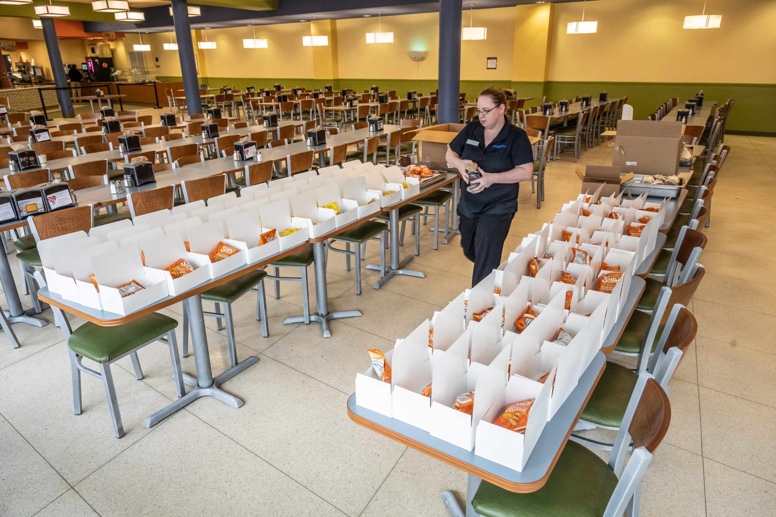 Dining services worker packing boxed lunches