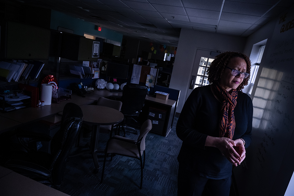 Dr. Channell Barbour stands in a dark office