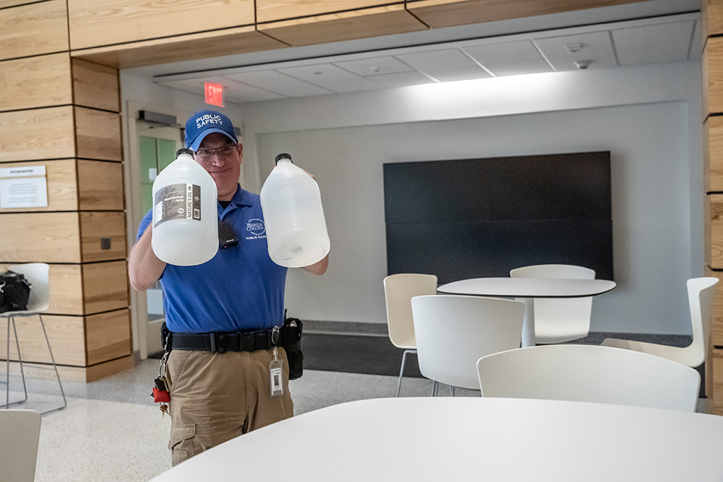 Public safety officer holding containers of hand sanitizer