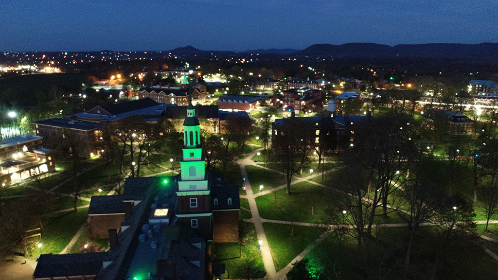 Ariel photo of campus towers lit green
