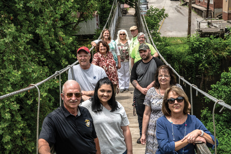 Members of Stay in Clay pose on the swinging bridge over Goose Creek.