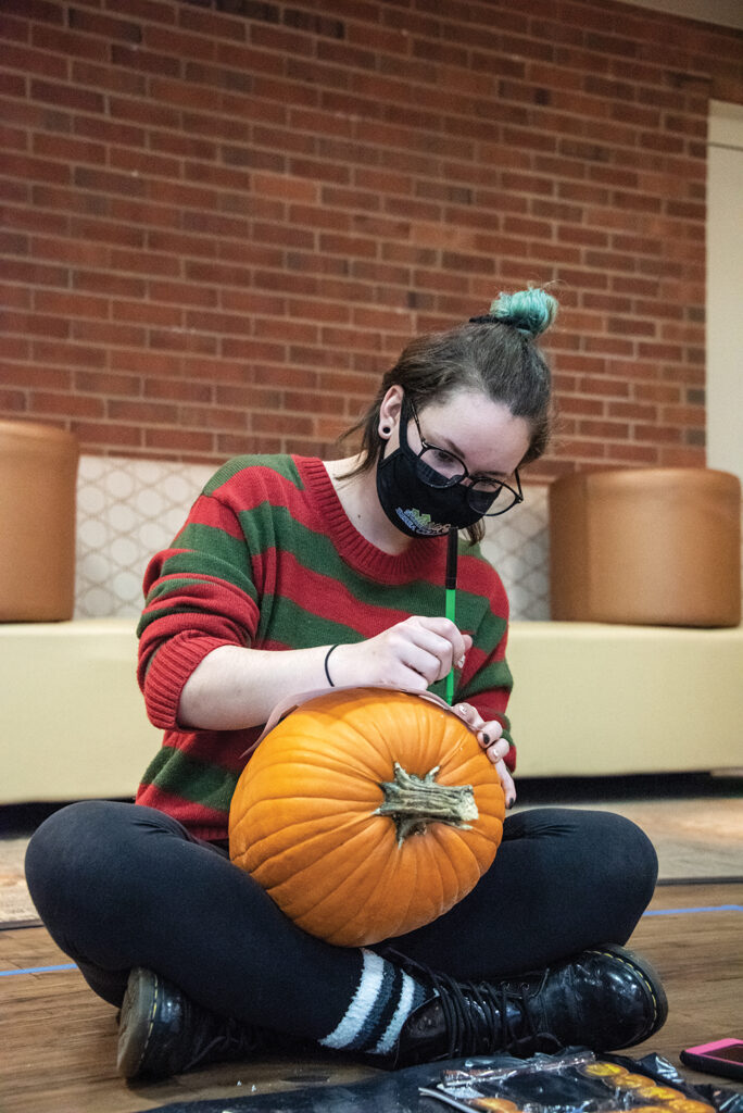 Willow Rodriguez caving a pumpkin in Baird Lounge