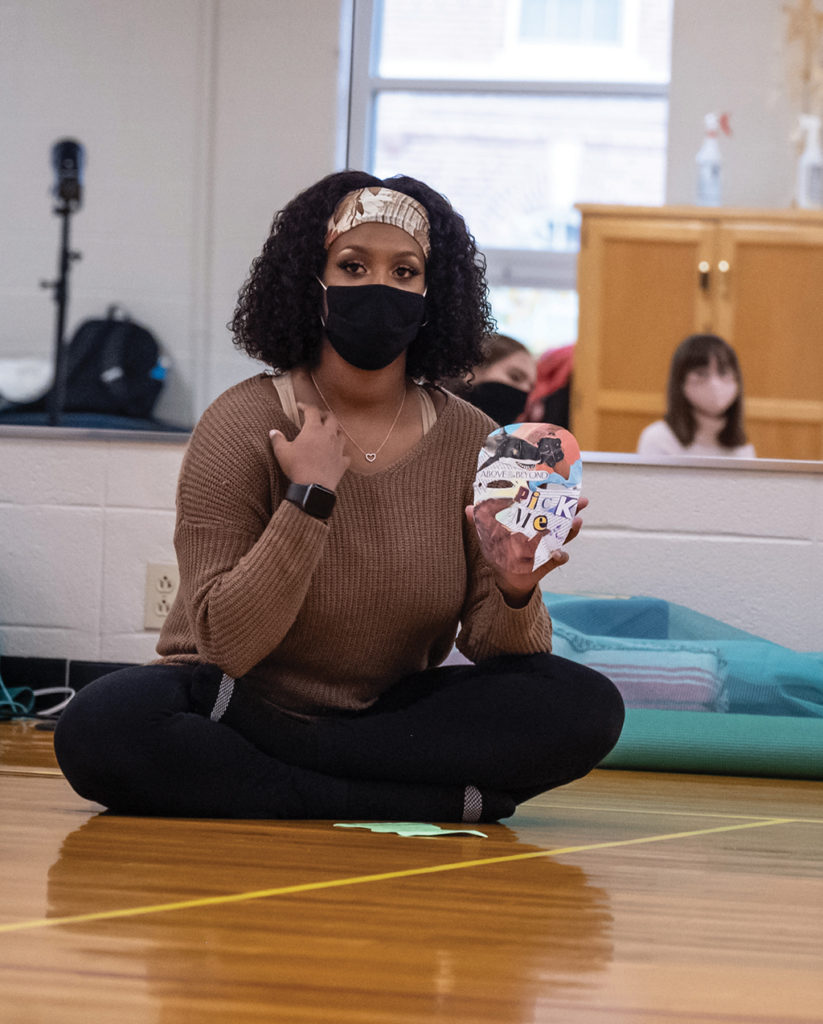 Berea student holds a mask while explaining about a class project