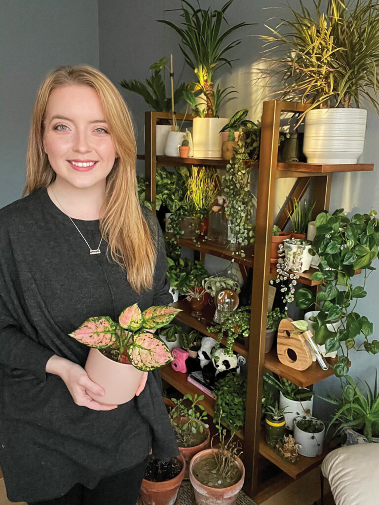Portrait of Bee Lakes in her home surrounded by her plant collection