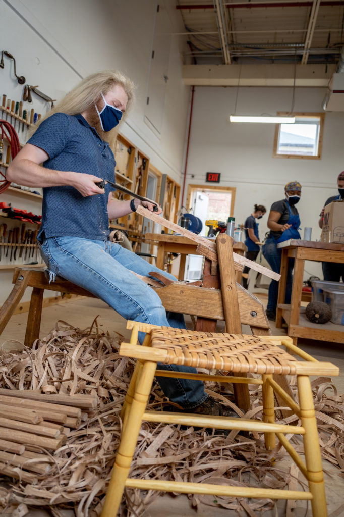 Student carving a Forest Stool as part of the Student Craft program