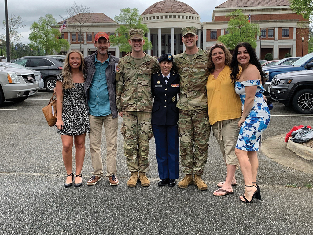 Corbin and Caleb Flege pose alongside their family and their recruiter