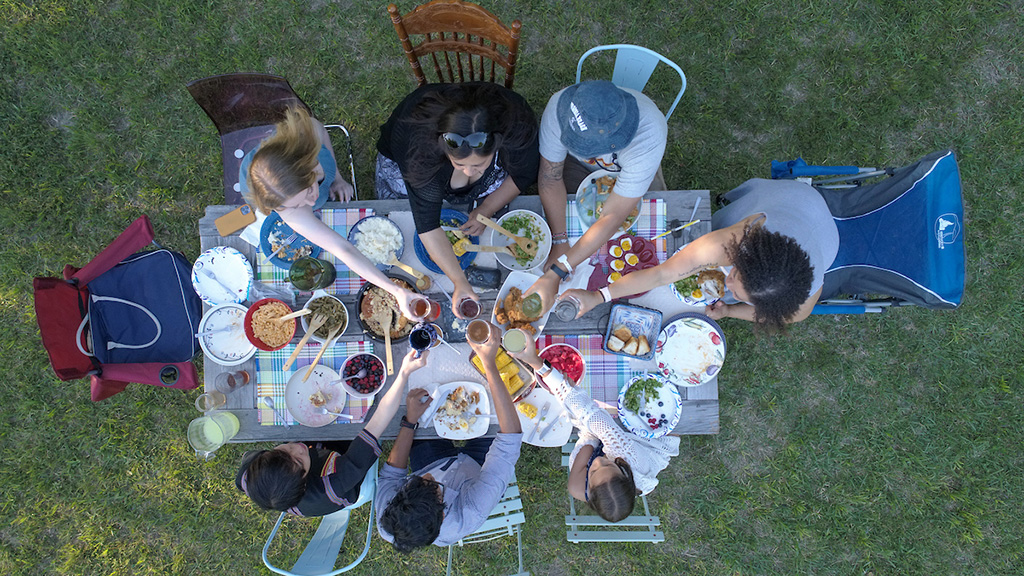 Drone shot above the table of Berea staff, students and alumni toasting over a meal