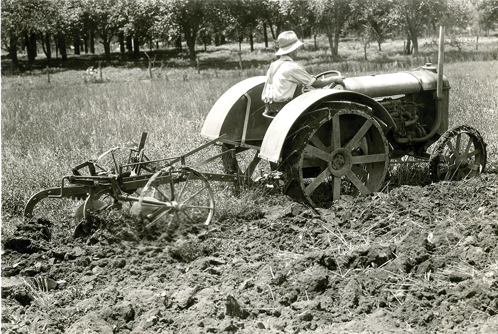 black and white photo of a tractor tilling soil on the Berea College Farm