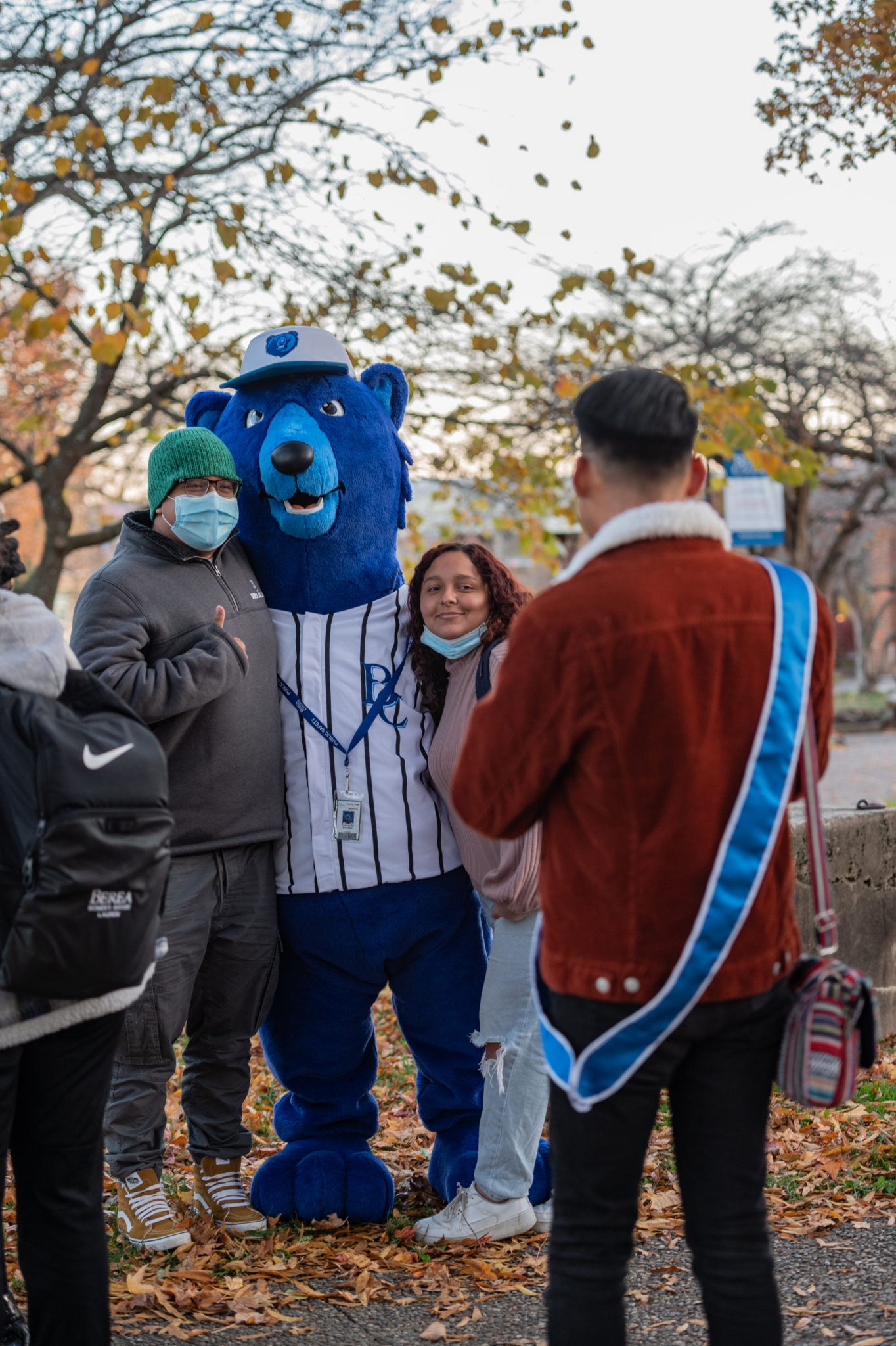Blue, the mascot, poses with students