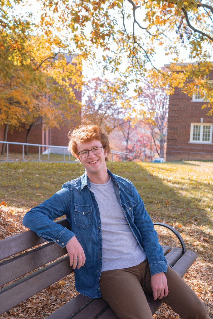 Portrait of Chase '24 sitting on a bench on campus