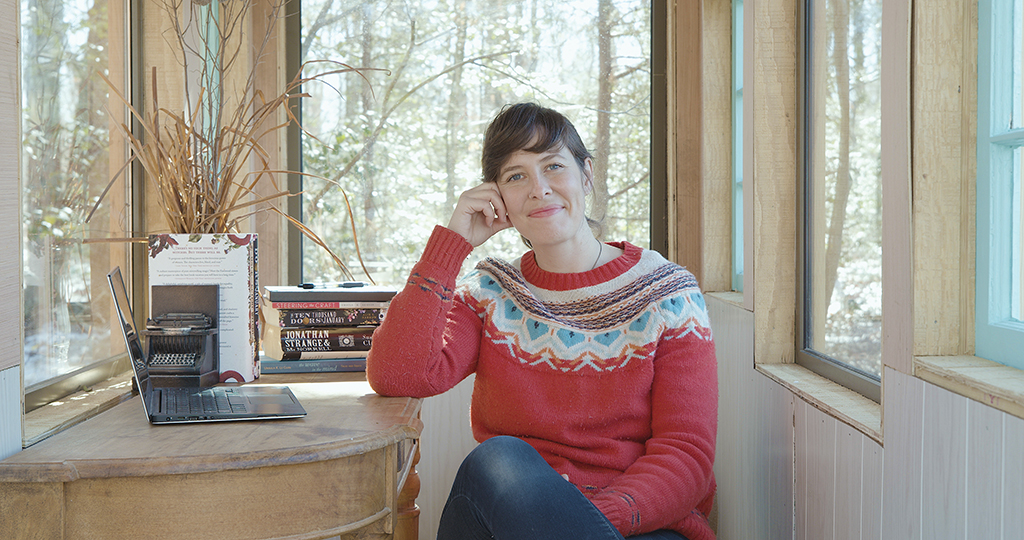 Portrait of Alix Harrow inside her writing shed
