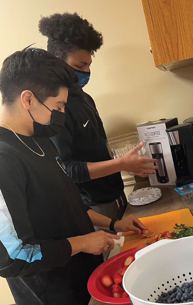 Two students prepare food for a First-Year Bonner Shcolars after-school program