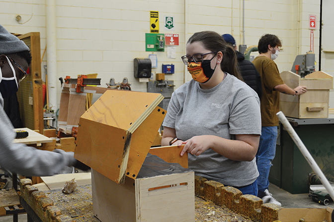 Student building a beehive habitat in TAD 140