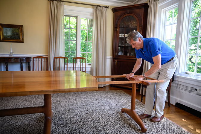 Photo of President Lyle Roelofs helping put together a table