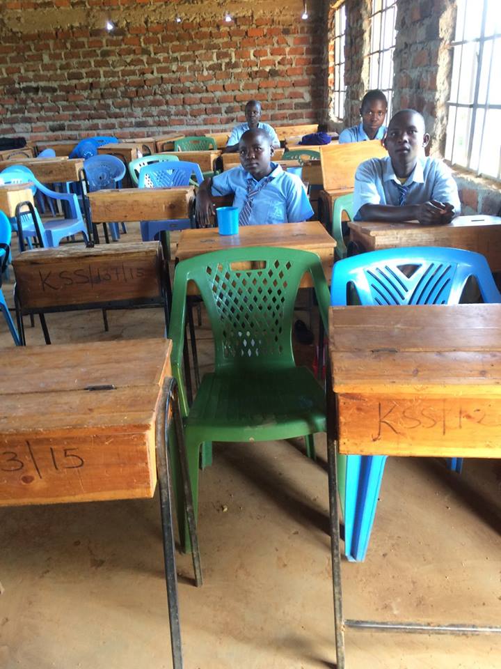 students sitting at desks inside of the school building