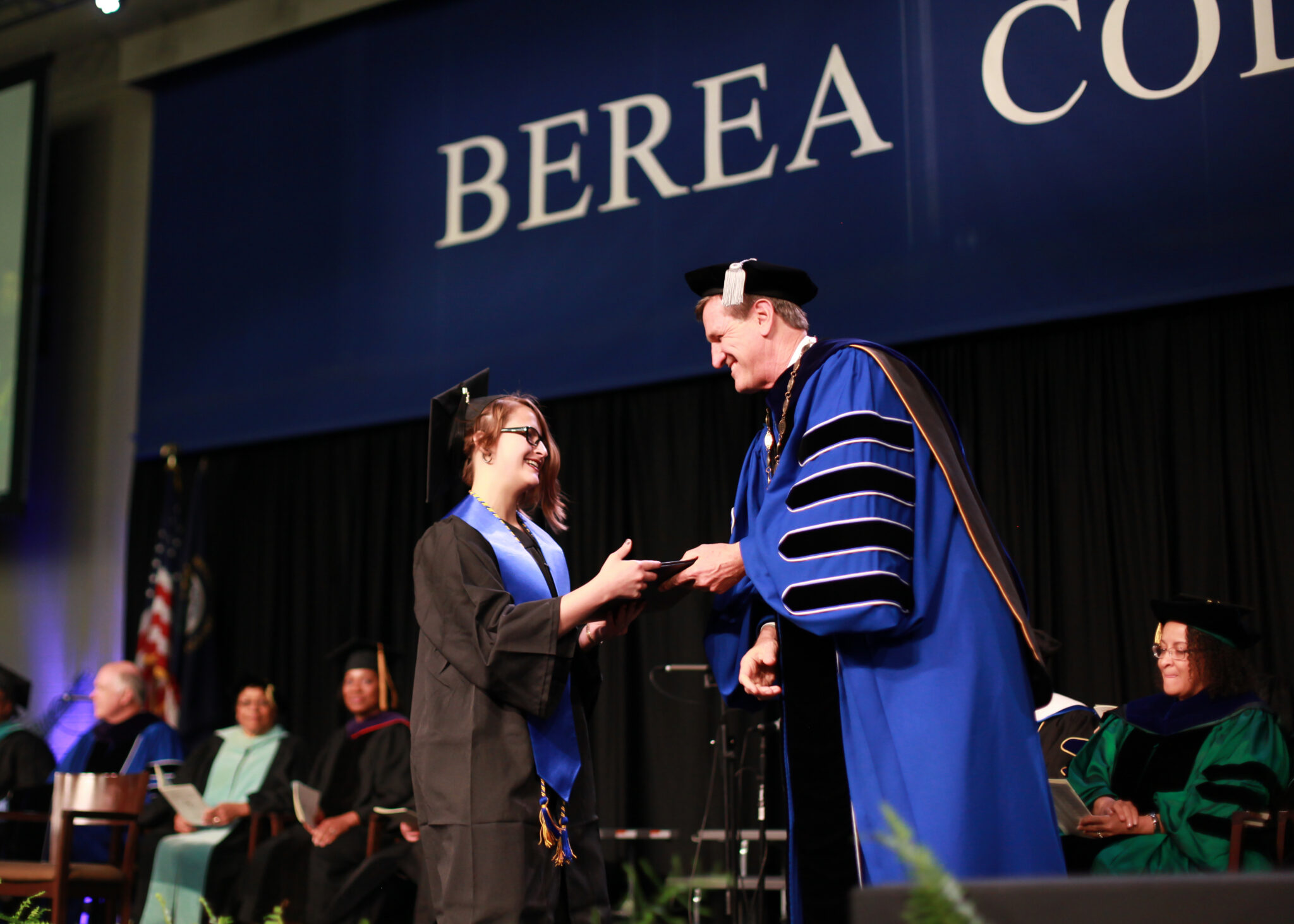 Photo of Berea College student shaking hands with President Roelofs on the graduation stage.