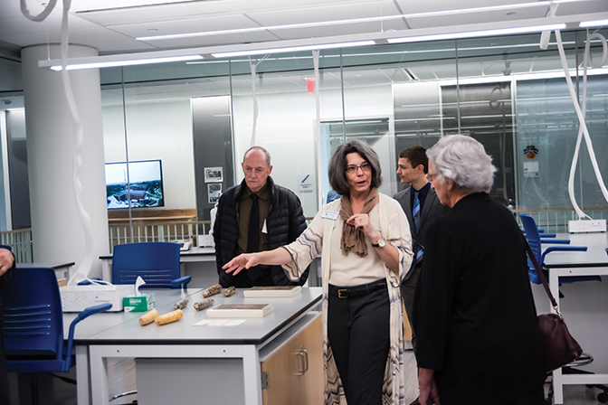 Photo of Dr. Megan Hoffman showing visitors around a lab in the newly constructed MAC building
