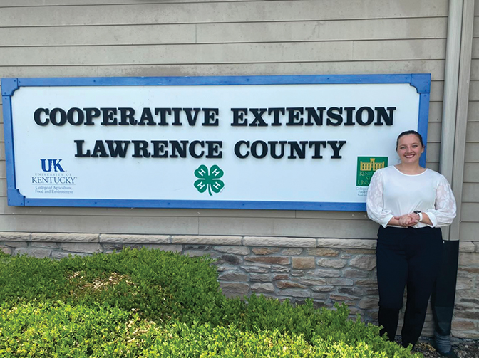 Sarah Deal standing with a Lawrence County Cooperative Extension sign