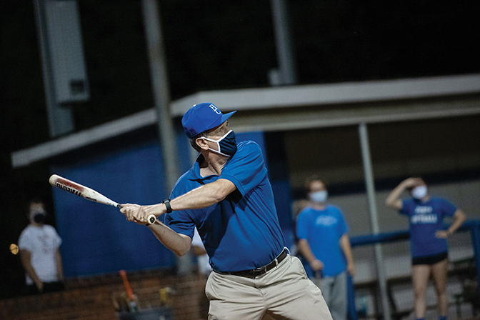 Lyle Roelofs wears a mask while swinging a bat at a baseball game