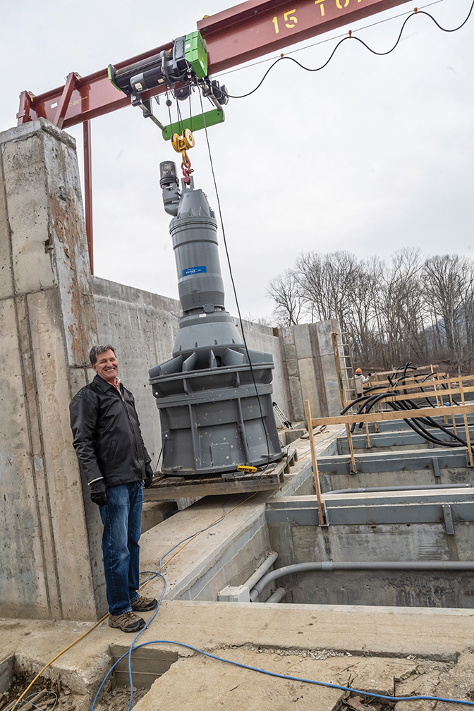 Lyle Roelofs standing next to a large piece of the hydroelectric station Berea built.
