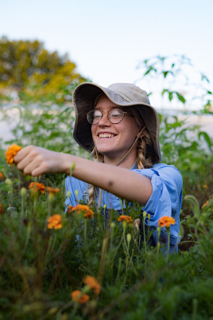 Student, Elaine, picking flowers in the College gardens