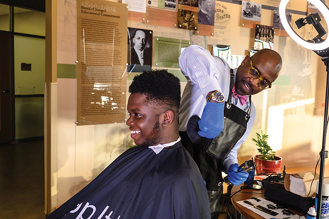 Joel Wilson ‘02 gives Victor Faluyi ‘23 a trim at a Chop It Up event last fall.