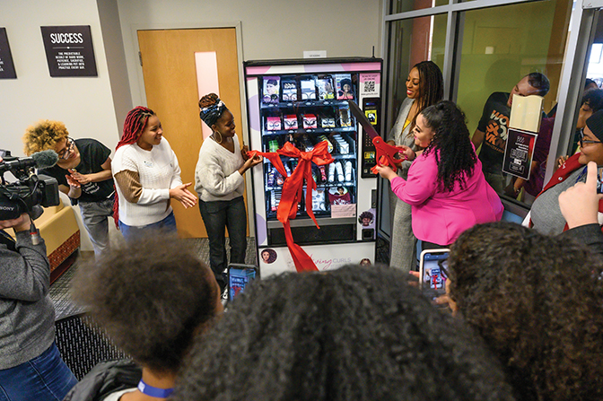 Students gather to watch the ribbon cutting on the new hair-care vending machine.