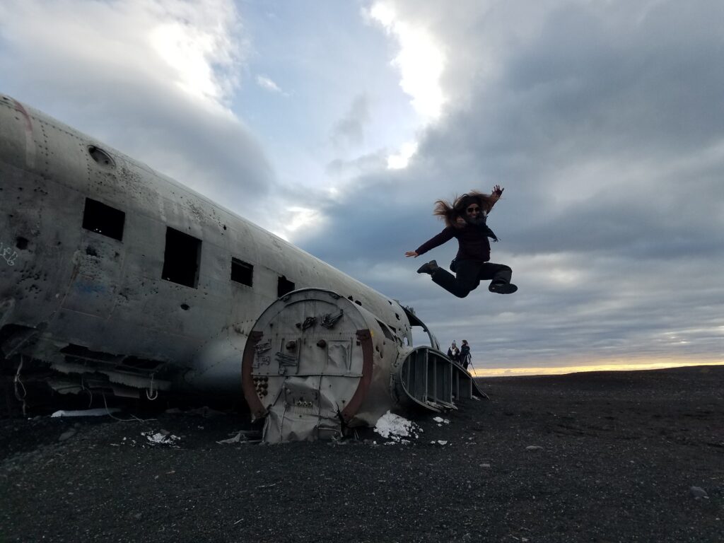 silhouette of a person jumping from plane wreckage