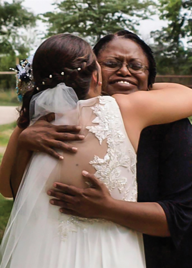 Dr. Althea Webb hugging a woman in a wedding gown.