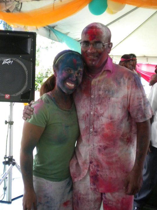 Princess Nash stands with the president of Guyana all covered in colored paint
