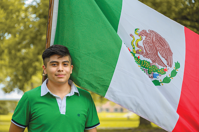 Jose ’26 stands with the flag representing his home country of Mexico.