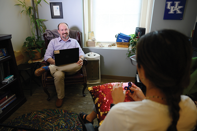 Counselor Josh Johnston talks with a student in his office