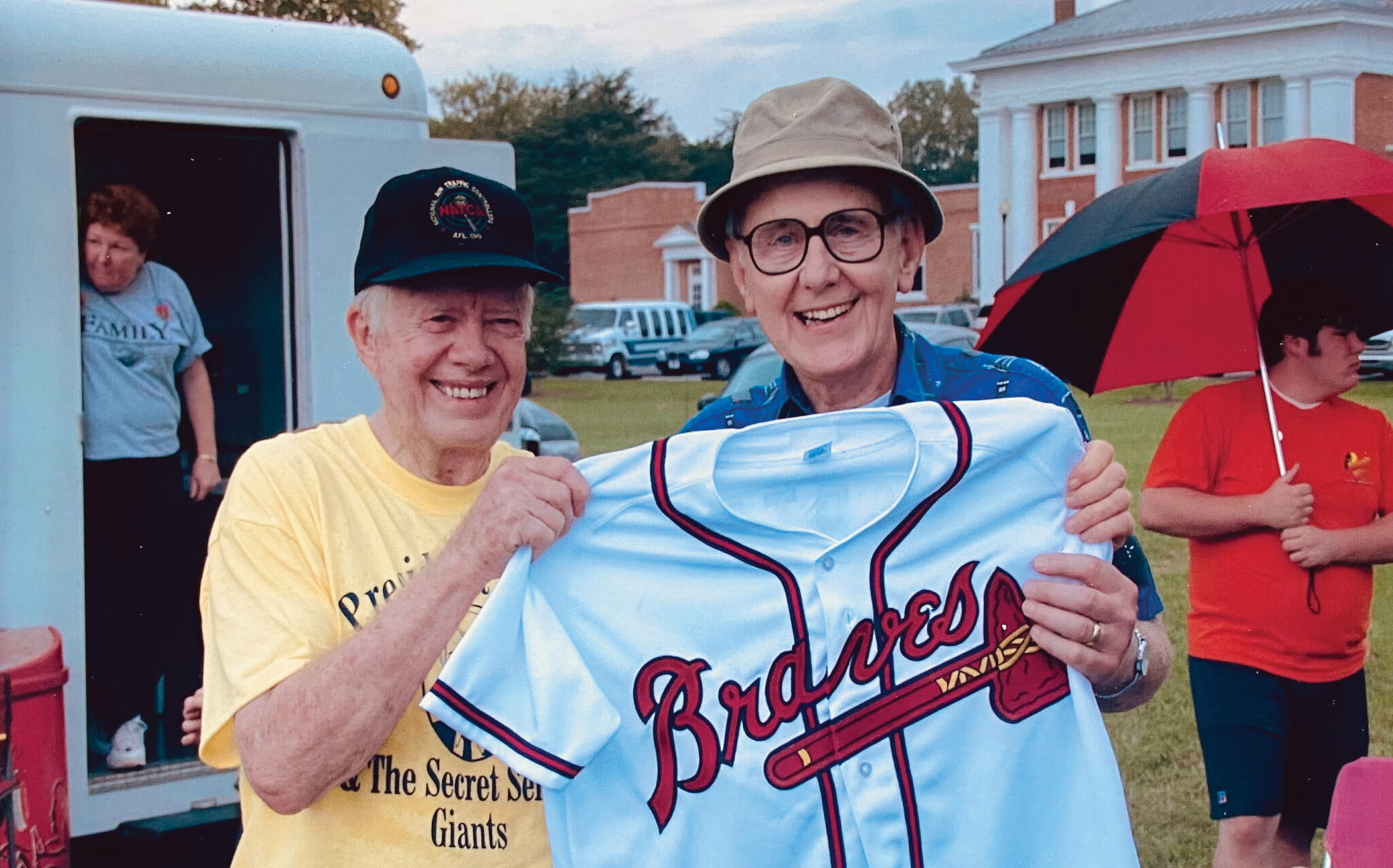 Photo of Doug Kelley with former President Jimmy Carter holding a Braves baseball jersey.