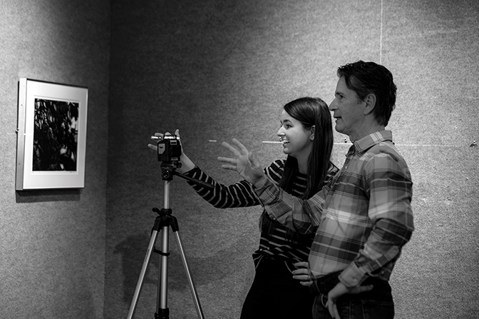 Joseph Goins and Kelsey Malone look discuss how and where to hang a photograph in the Doris Ulmann upper gallery