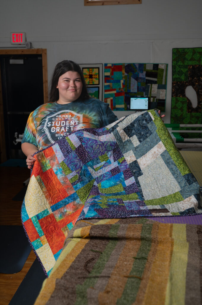 Dani '25 holds a colorful quilt.