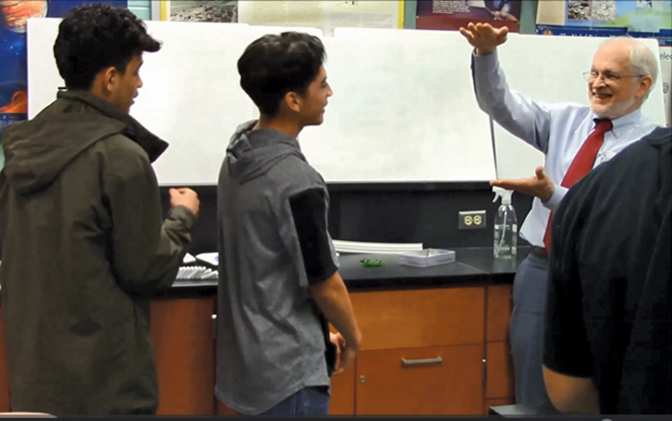 photo of George Dewey in a classroom speaking to two students