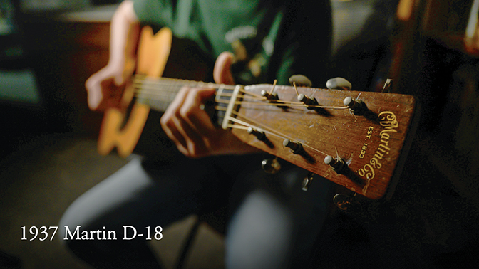 Upclose image of hands on the neck of guitar