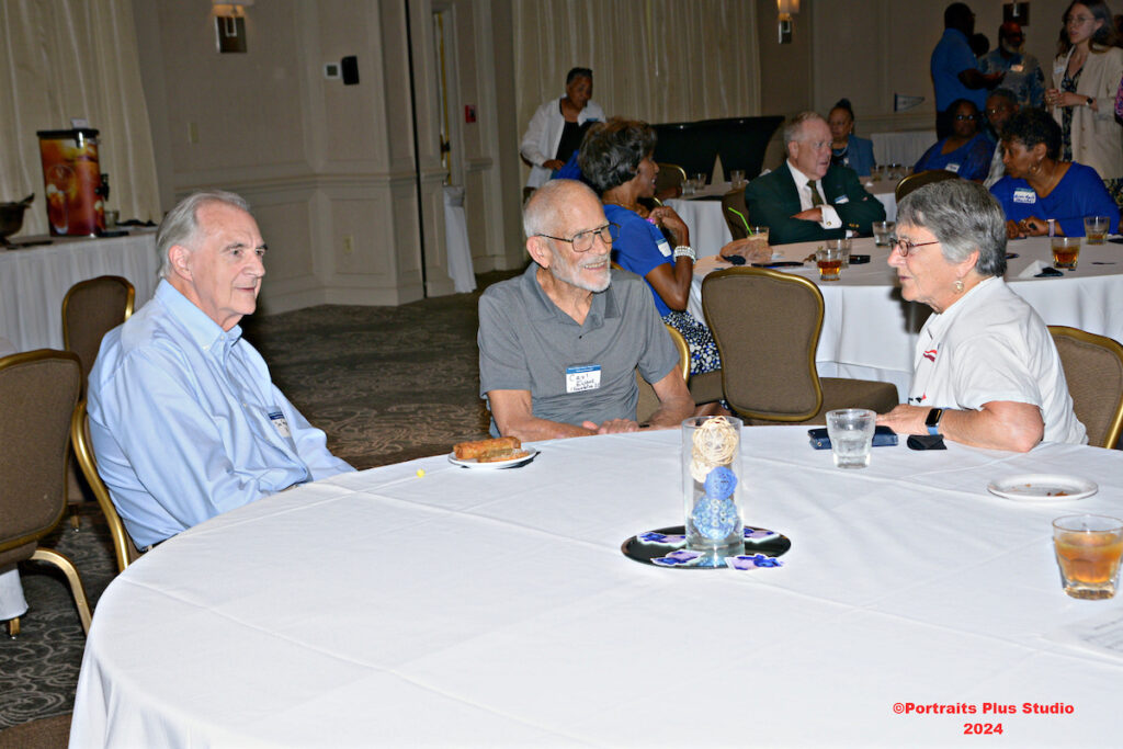 Several Greenville alumni talk together at a table
