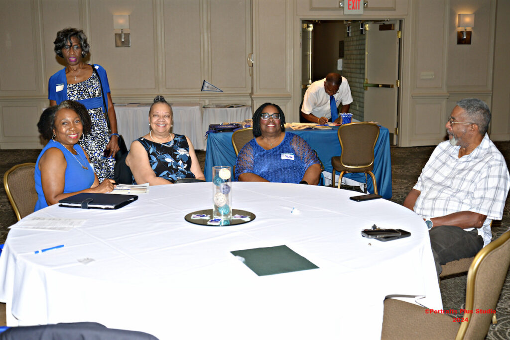 Several Greenville alumni talk together at a table