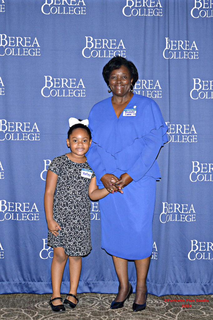 Berea College alumna Brenda Lane '79 stands with a young child
