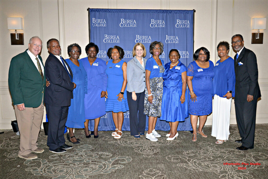 Posed picture of a group of Greenville alumni and President Cheryl Nixon. 