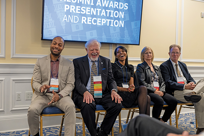 Four alumni laugh during the Alumni Awards ceremony in the Boone Tavern Event Center