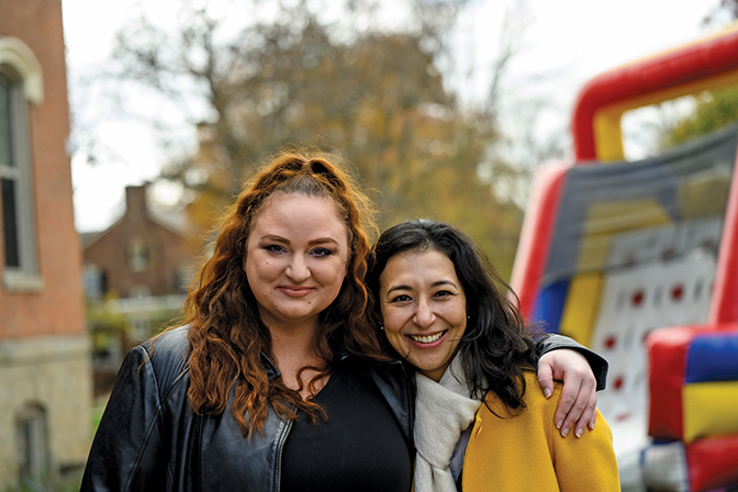 Two female alumni pose for a picture.
