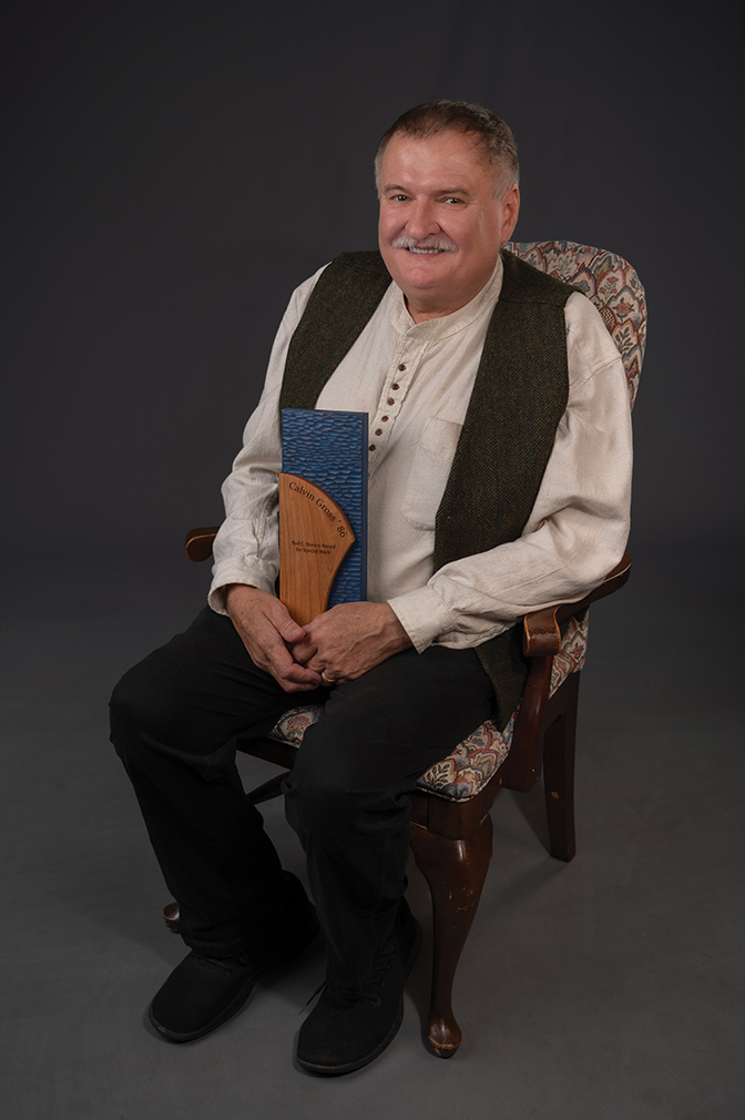 Portrait of Calvin Gross '85 holding his alumni award